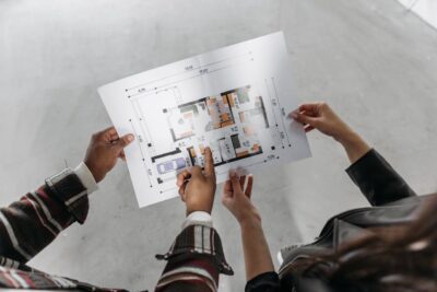 Two people looking at a house blueprint when buying a property in Canada