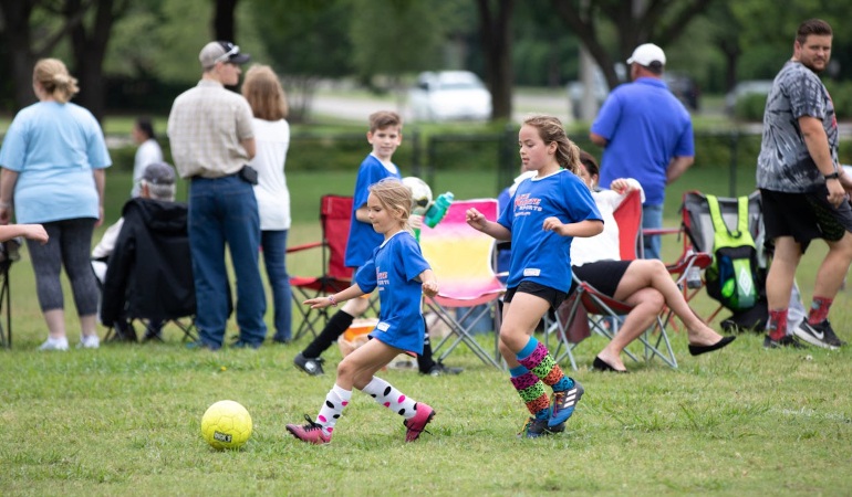 Two girls with cute, colorful socks chasing a ball