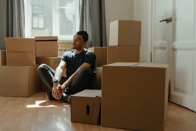 Person thinking while sitting among boxes