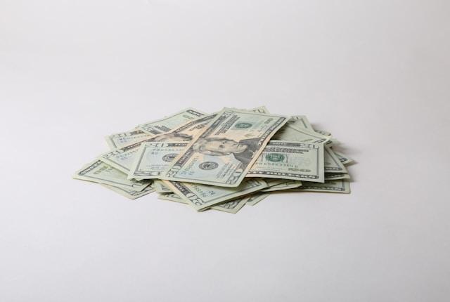 A pile of money sitting on a white surface
