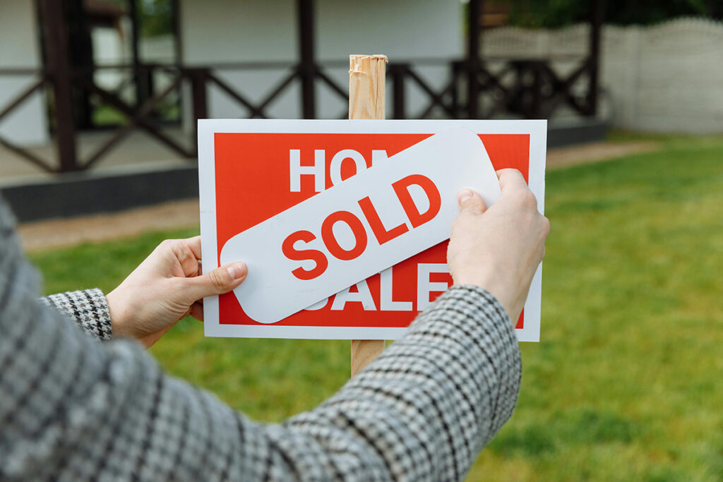 A realtor posting a sold sticker